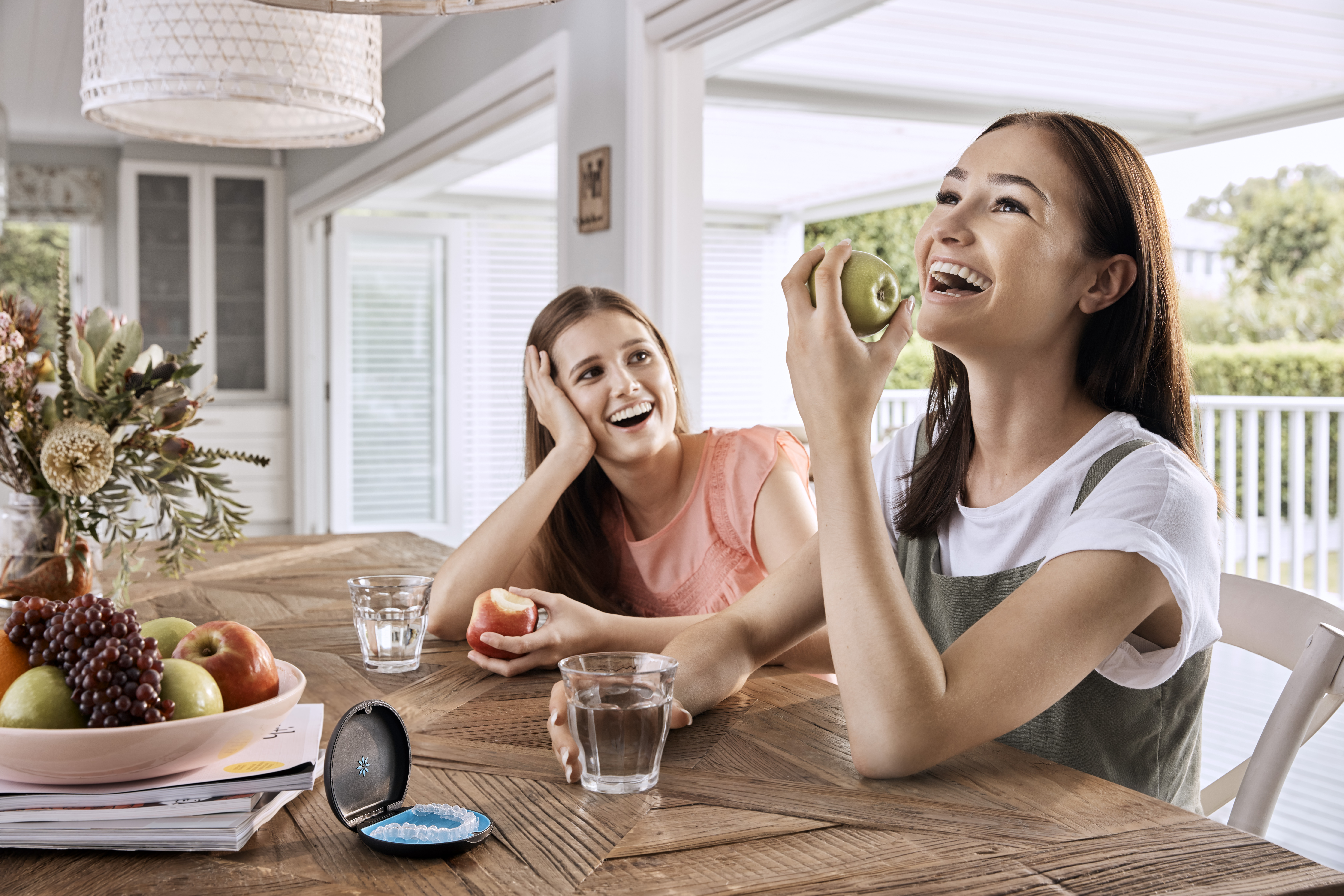 Teenagers enjoying fruit with Invisalign Teen clear aligners